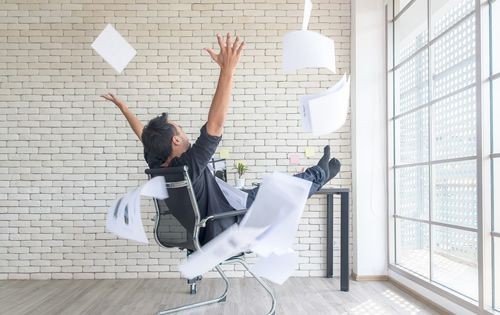 man-excited-throwing-papers-in-air